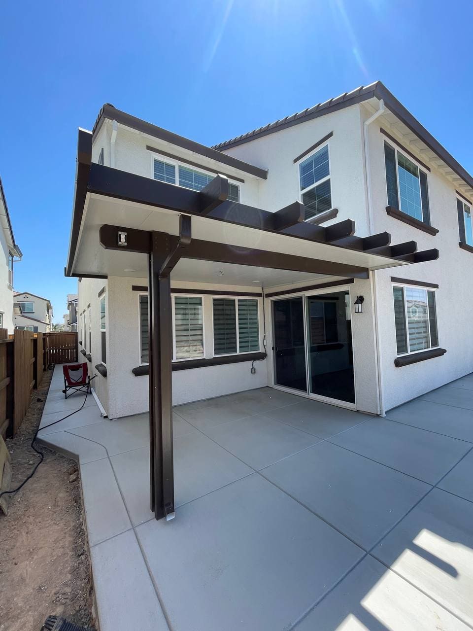 Two-tone attached insulated solid aluminum patio cover with dark bronze trim and recessed lights in Folsom, CA.